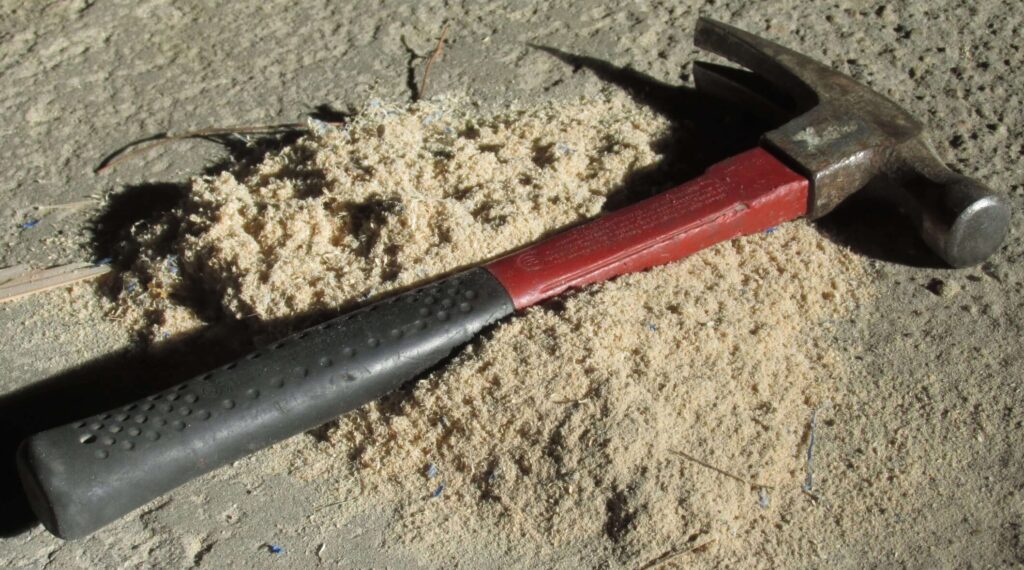 Logo for DustyDIY.com, hammer in sawdust